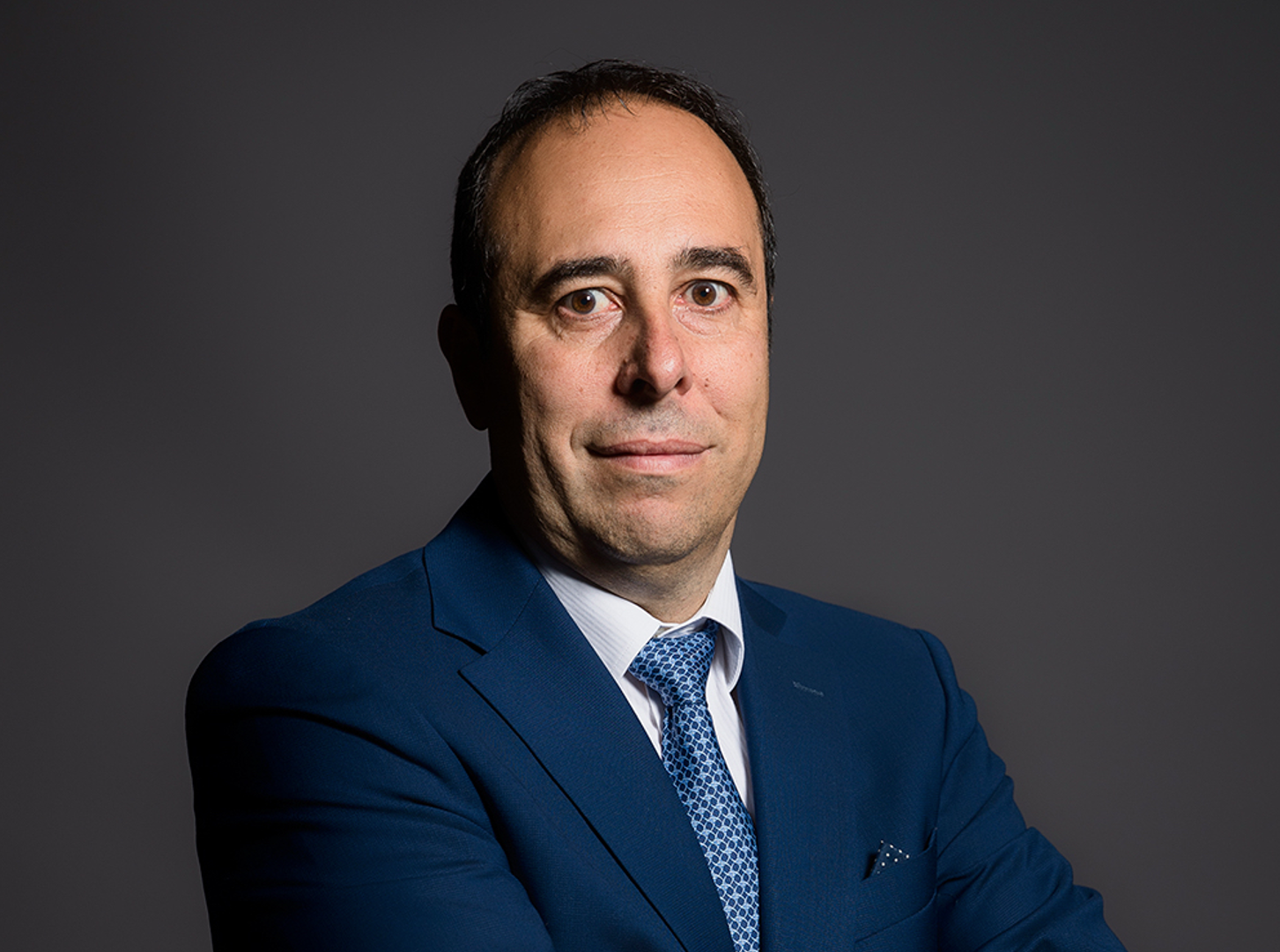 Massimo Fedeli, Managing Director von Hiscox Italia, trägt einen dunkelblauen Anzug und Krawatte. 