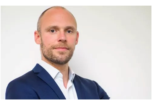 Michael Hofmann trägt ein blaues Sakko und ein weißes Hemd