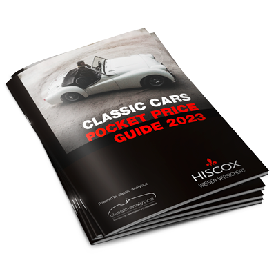 Gestapelte Booklets mit dem Titel ‚CLASSIC CARS POCKET PRICE GUIDE 2023‘ und einem weißen Cabrio auf dem Cover, gebrandet mit dem HISCOX-Logo.