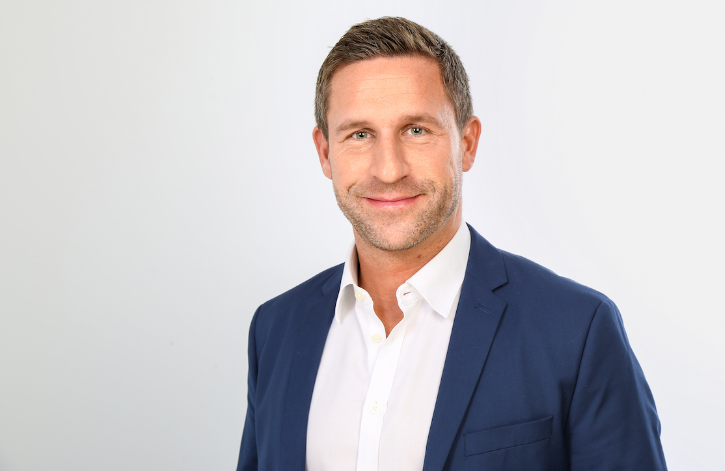 stefan sievers trägt ein weißes Hemd und ein blaues Sakko.