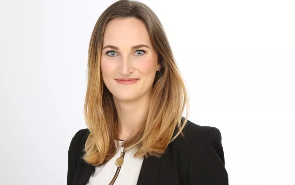 Gisa Kimmerle, Head of Cyber, trägt einen schwarzen Blazer und lächelt in die Kamera.