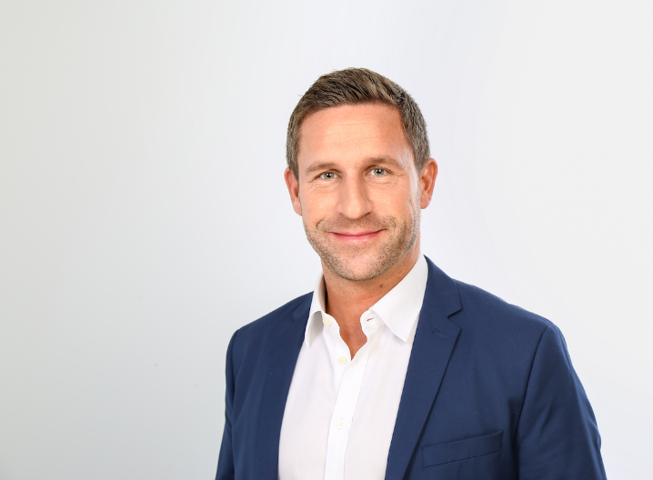 stefan sievers trägt ein weißes Hemd und ein blaues Sakko.