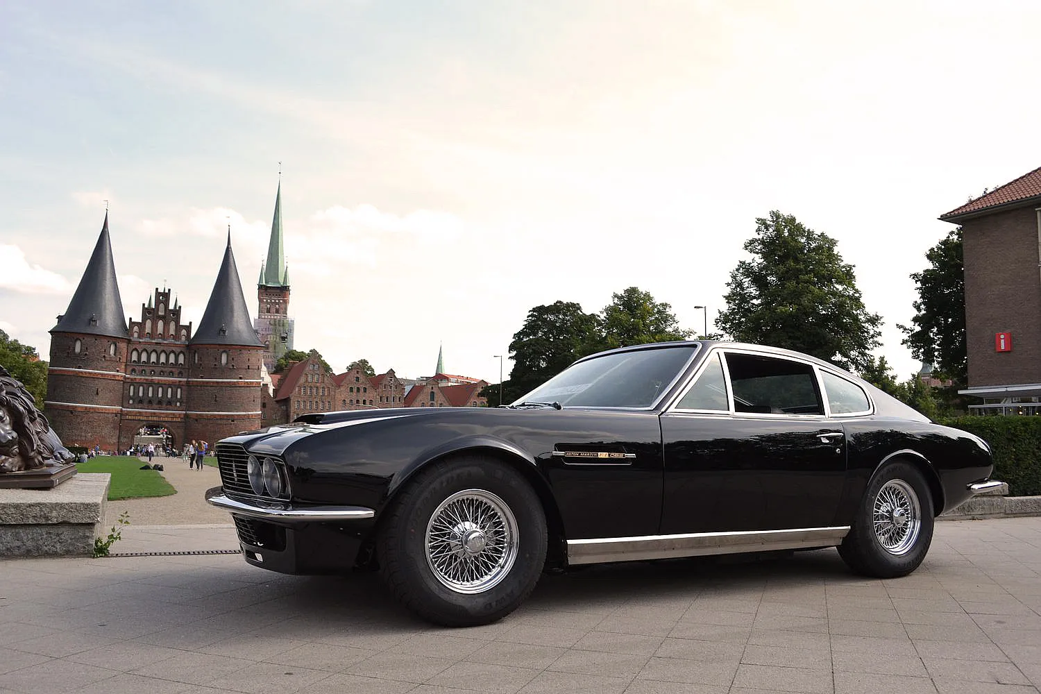 Schwarzer Aston Martin vor dem historischen Holstentor in Lübeck, Deutschland