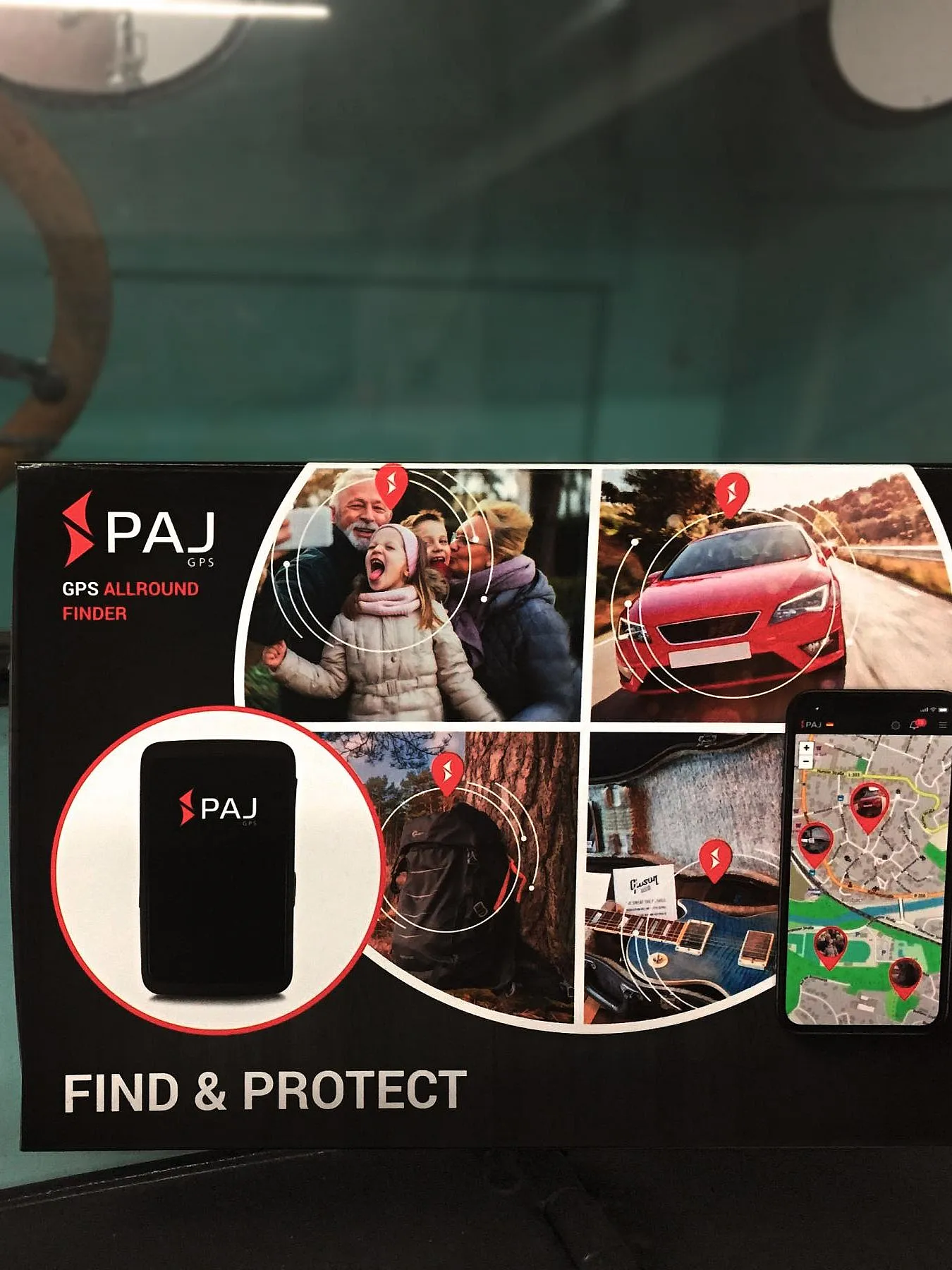 Ein türkiser Oldtimer mit einem Schild, welches die Werbung für den GPS-Tracker "PAJ" zeigt.