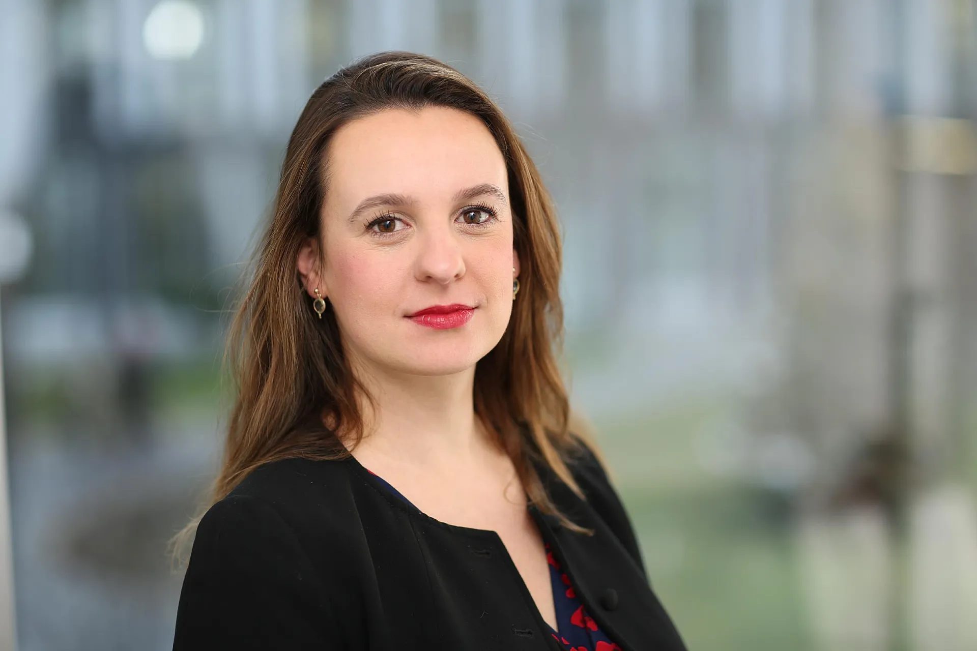 Alina Sucker mit rotem Lippenstift und schwarzer Blazer bei der Arbeit für Hiscox - Head of Art & Private Clients, Property & Event