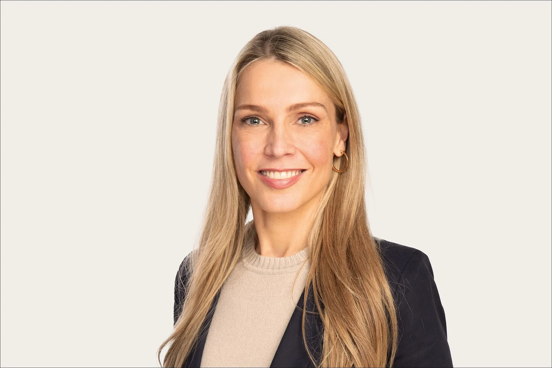 Franziska Beran, Head of Partnerships bei Hiscox, trägt einen dunklen Blazer und lange Haare und blickt lächelnd in die Kamera