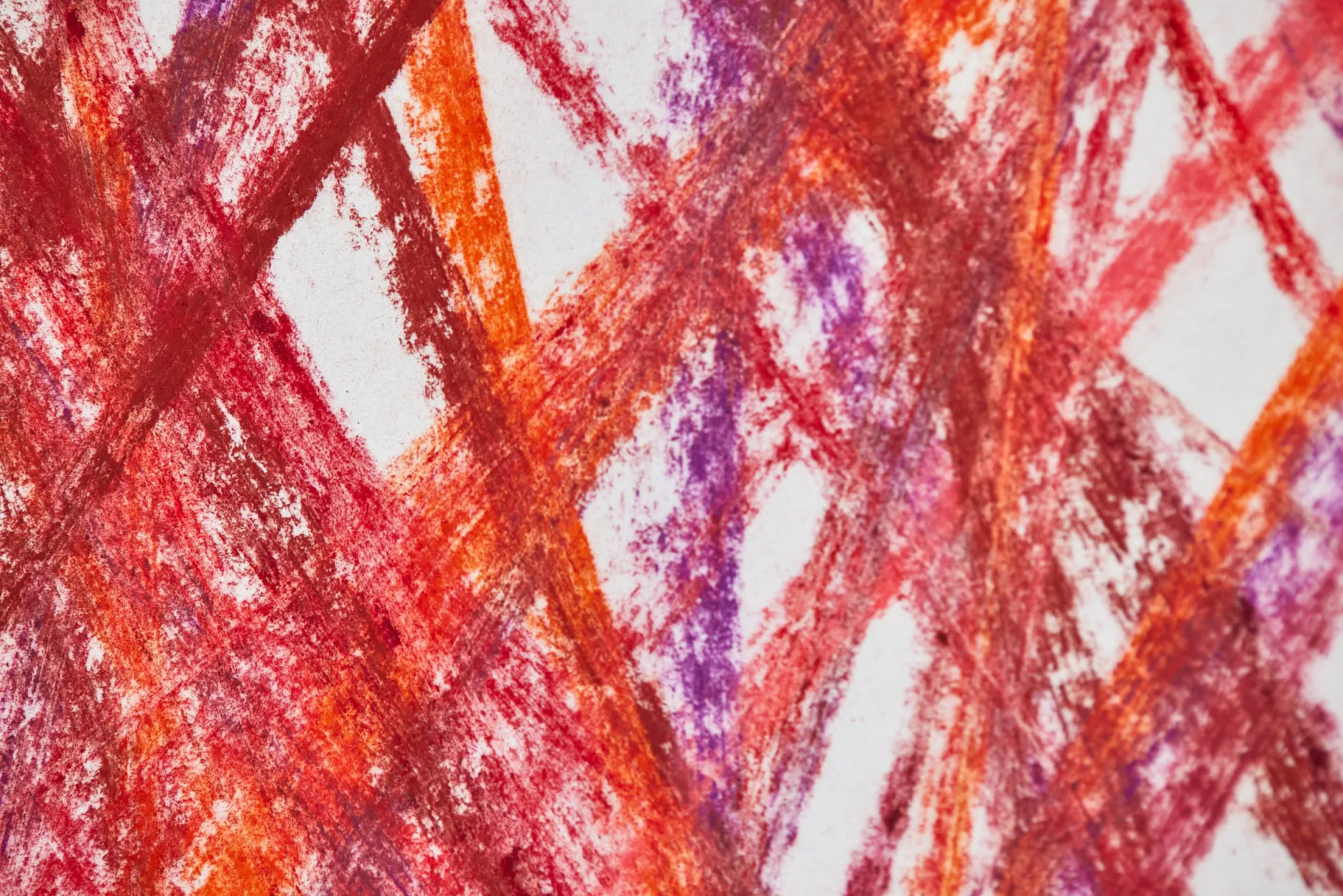 Das Bild zeigt eine Nahaufname von einem Kunstwerk, deren Linien mit Kreidefarben in verschiedenen Rottönen und lila Farbe gezeichnet sind.