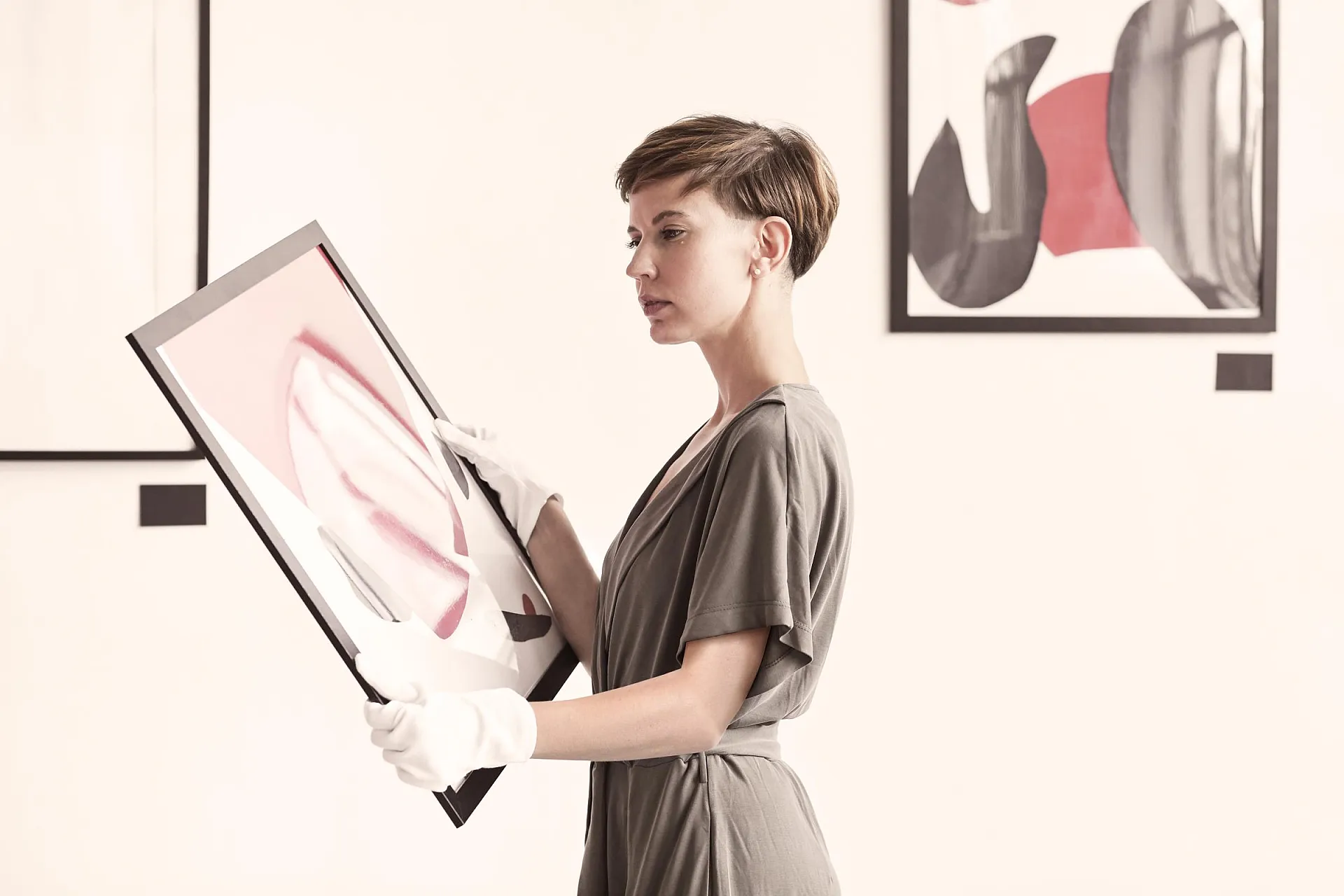Kunstversicherung für Gallerien und Museen von Hiscox: Galleristin hält Kunstwerk in den Händen