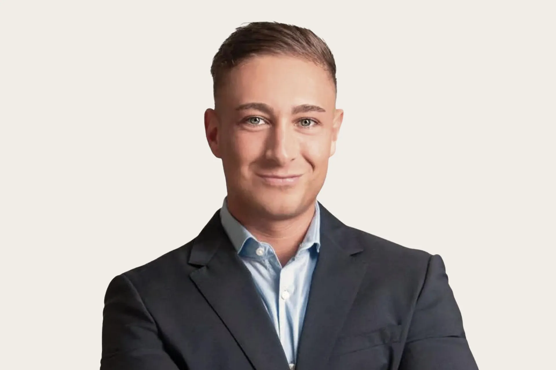  Ein Mann in einem dunklen Anzug und einem hellblauen Hemd vor einem neutralen Hintergrund.