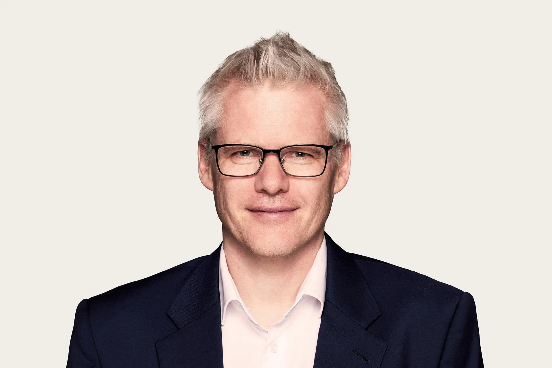 Martin Schirmbacher ist Rechtsanwalt bei Härting Rechtsanwälte. Er trägt einen Anzug sowie eine Brille und blickt lächelnd in die Kamera.