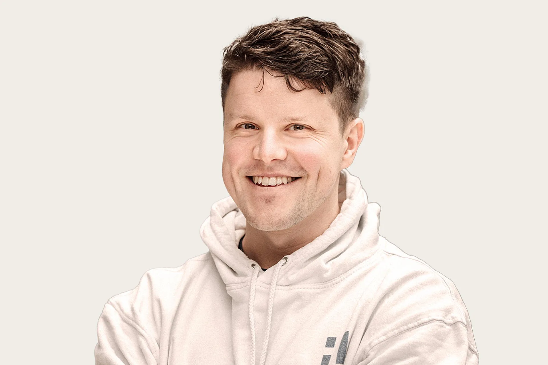 Michael Gäfgen ist Krisenmanager bei HiSolutions. Er trägt einen weißen Kapuzenpullover und lacht in die Kamera.