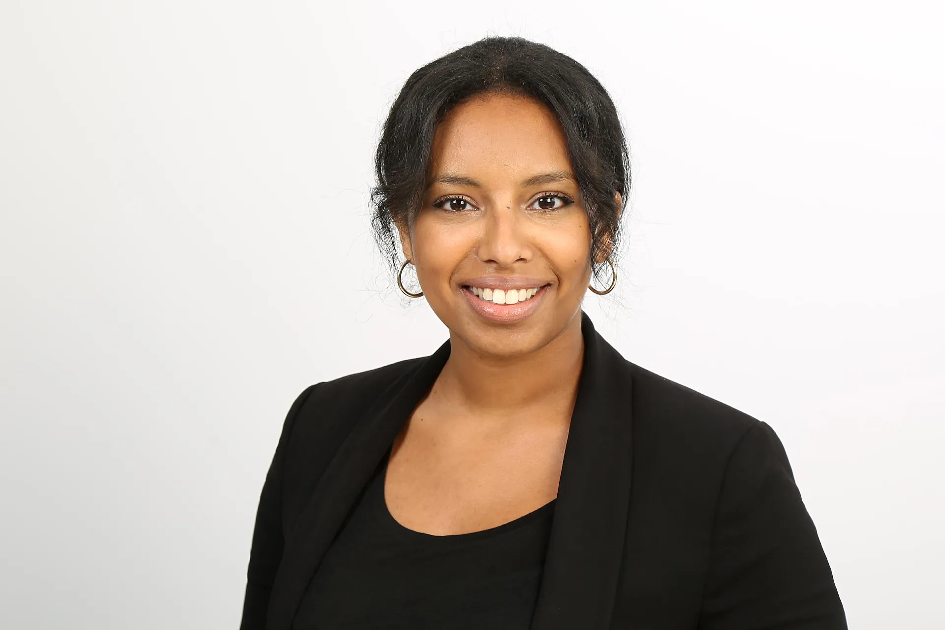 Semret Haile trägt einen schwarzen Blazer und ein schwarzes Oberteil.