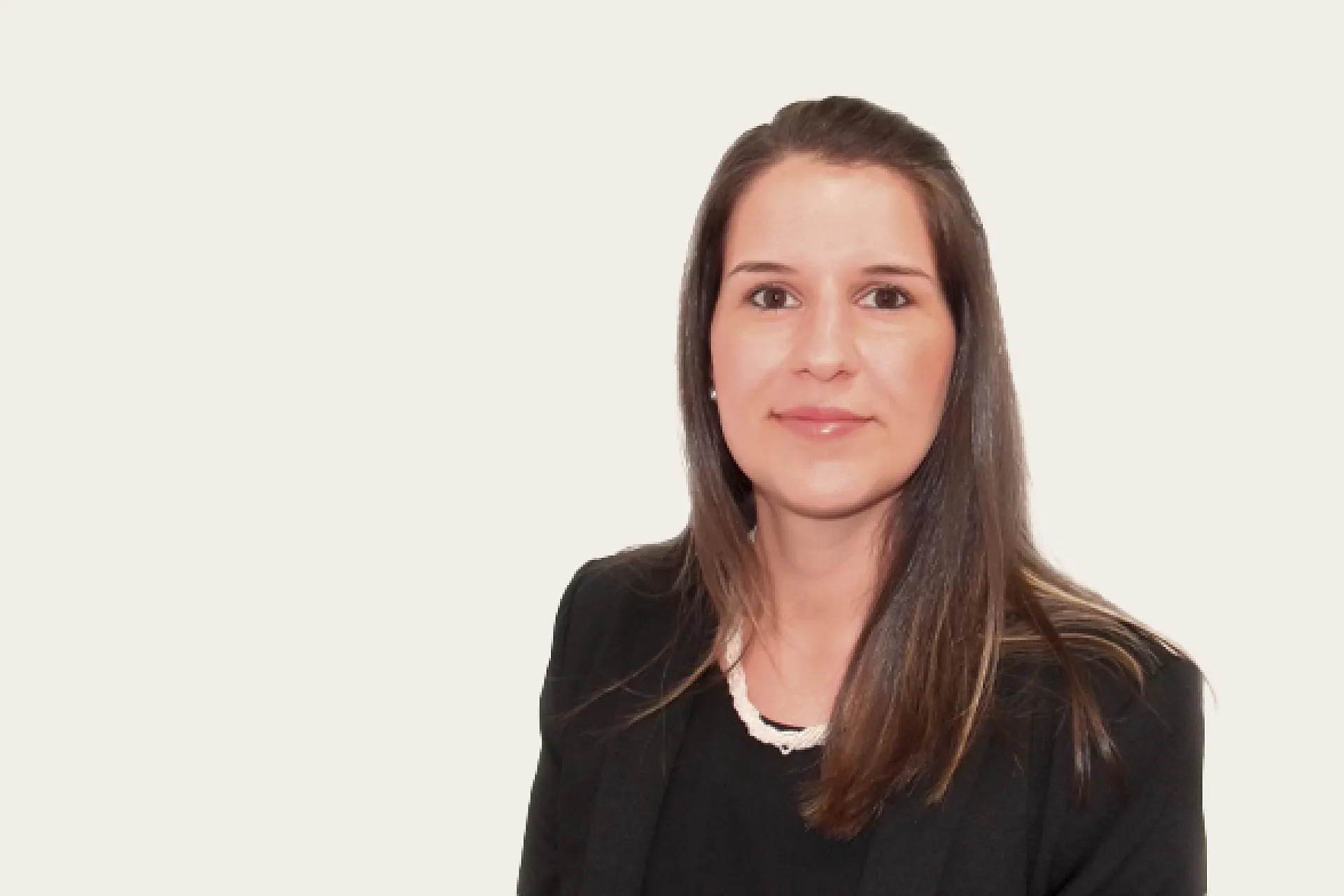 Tania Agostino, eine Frau mit langen braunen Haaren, trägt einen schwarzen Blazer und eine weiße Halskette.