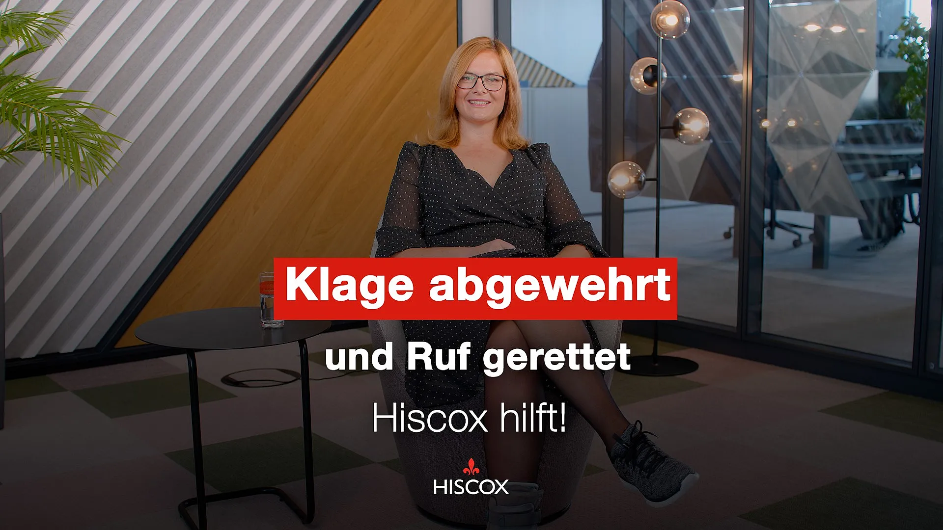 Hiscox Underwriter Martina Korch, tätig in der Schadenabteilung, trägt eine Brille und ein Kleid