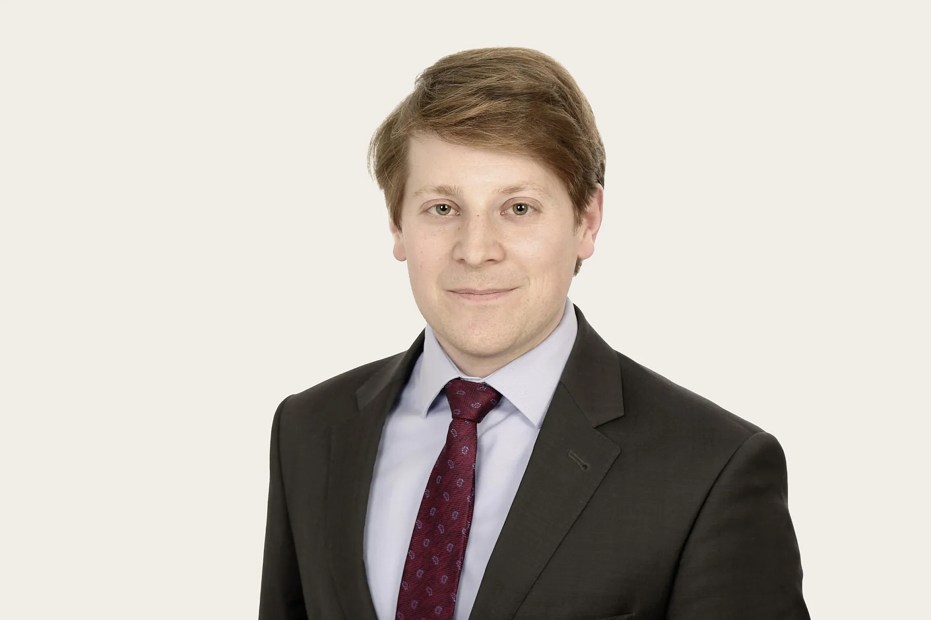 Ulrich Herz den Proposition Manager bei Hiscox trägt einen  dunklen Anzug und weißen Hemd vor weißem Hintergrund.