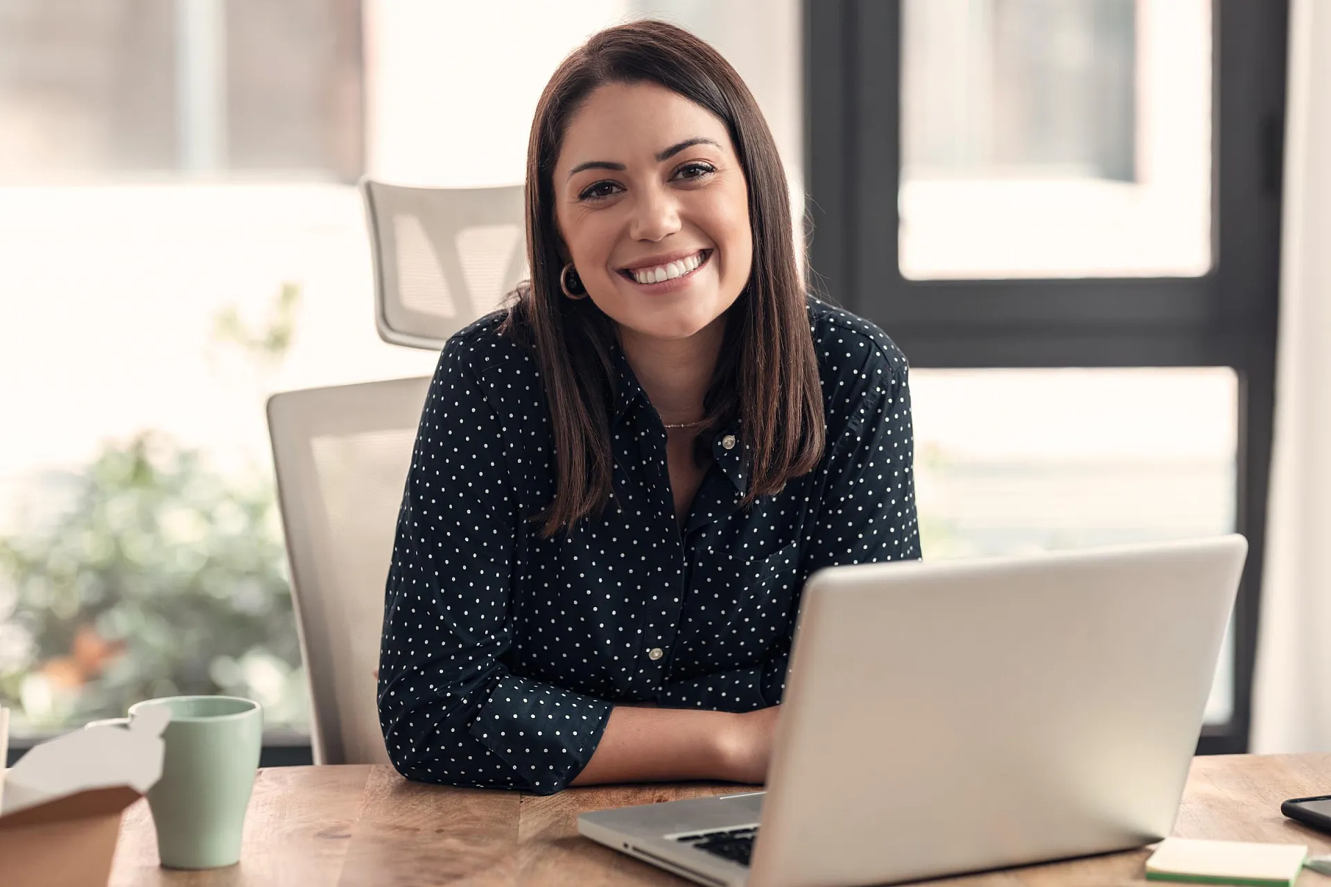 Lächelnde Frau am Laptop im Homeoffice: Positive Arbeitsatmosphäre und berufliche Kommunikation