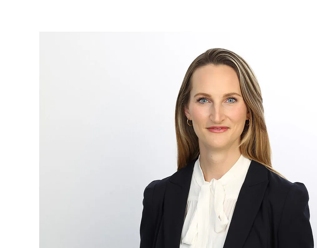 Gisa Kimmerle, eine Frau mit langen und glatten Haaren, trägt einen schwarzen Blazer und eine weiße Bluse.