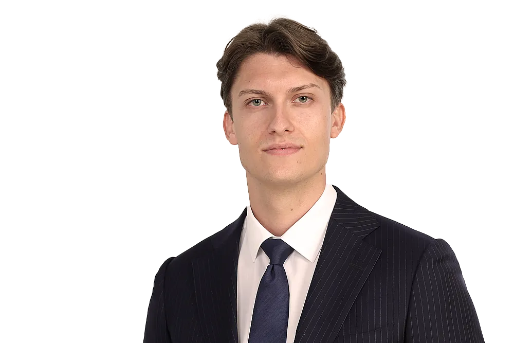 Leon Nitschke ist Underwriter für Art und Private Client bei Hiscox. Er trägt einen schwarzen Anzug mit weißem Hemd und schwarzer Krawatte. Er hat dunkelbraune Haare und lächelt leicht in die Kamera.