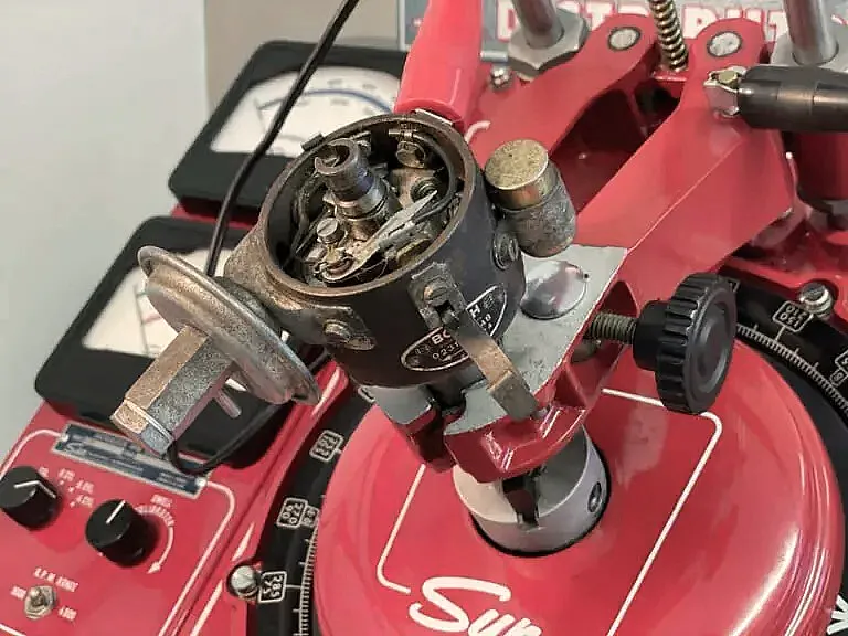 Nahaufnahme eines Vintage-Sun-Verteilertestgeräts mit verschiedenen Zifferblättern und Messgeräten zur Kalibrierung von Automobilverteilern.