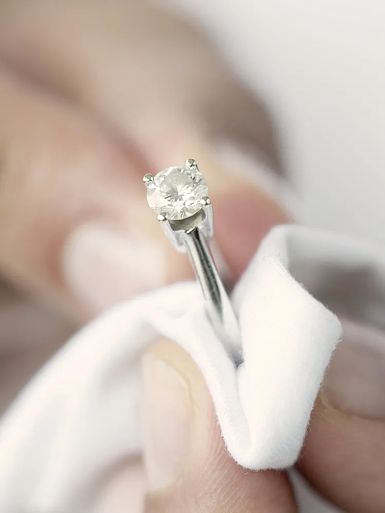 Ein Diamantring, der mit einem Tuch poliert wird