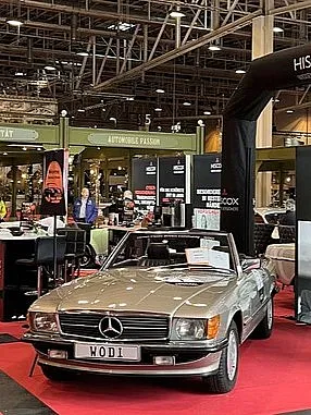 Blick auf den Messestand von Hiscox au der Oldtimer Fachmesse in Essen 2024mit Blick au ein Oldtimer-Model und Messeaufsteller