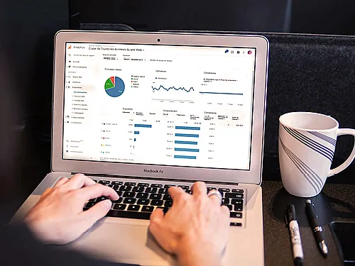 Ansicht eines Laptops, an dem ein Mann einen Google Ads Kampagne bearbeitet