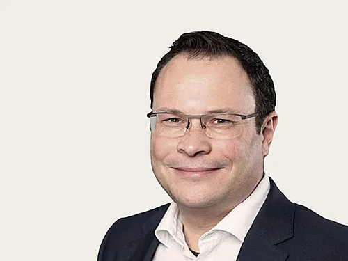 Ronny Schreib trägt ein dunkles Sakko und ein weißes Hemd.