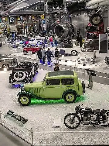 Ausstellung von Oldtimern und klassischen Fahrzeugen in einem gut beleuchteten Innenraum.