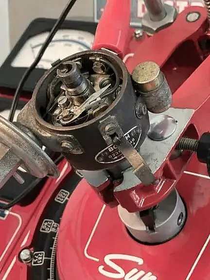 Nahaufnahme eines Vintage-Sun-Verteilertestgeräts mit verschiedenen Zifferblättern und Messgeräten zur Kalibrierung von Automobilverteilern.