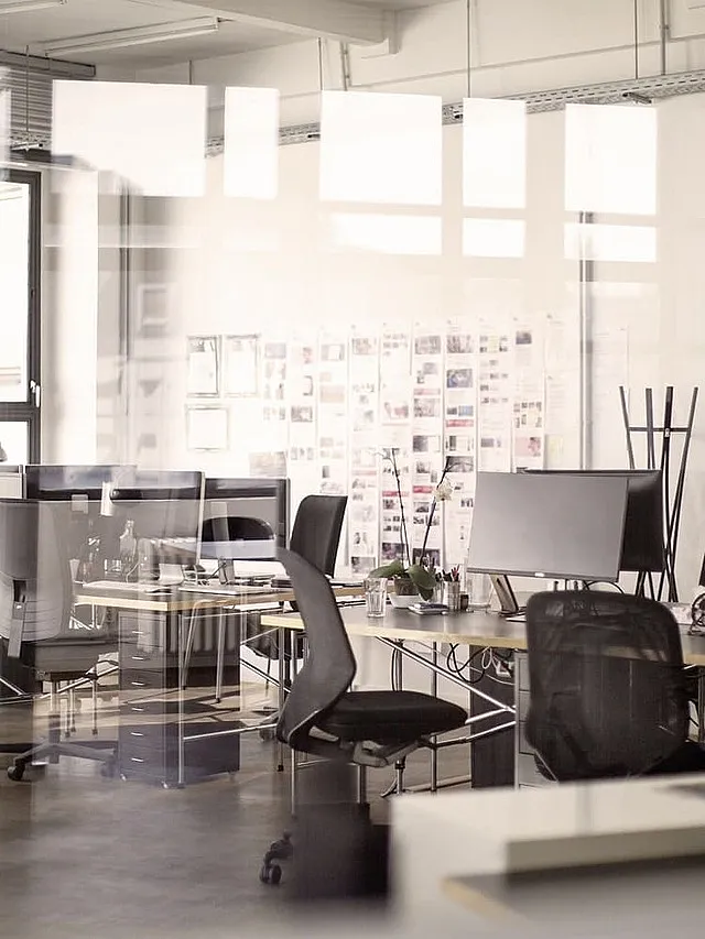 Sachversicherung von Hiscox: Büroraum mit Schreibtisch, Schreibtischstuhl und Büroeinrichtung