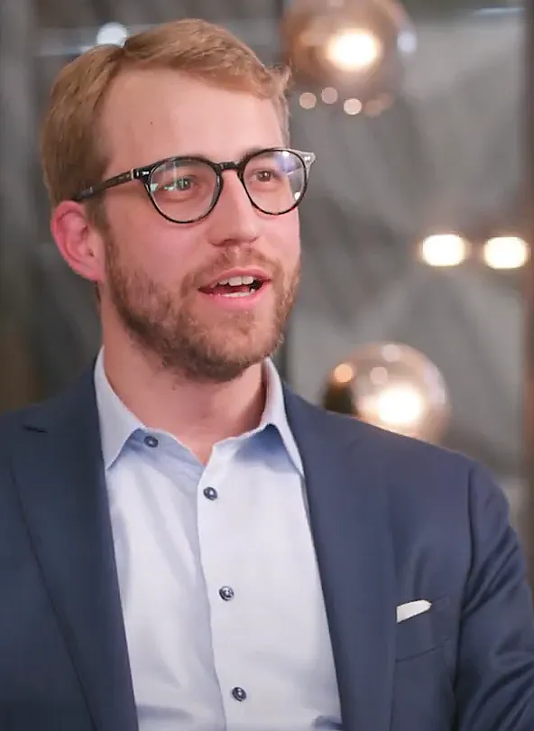 Underwriter Bastian Lutz trägt eine Brille und ein Sakko