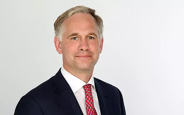 Wolf von Buchwaldt, Director Broker Sales, in Anzug und Krawatte steht vor einem weißen Hintergrund und lächelt leicht.