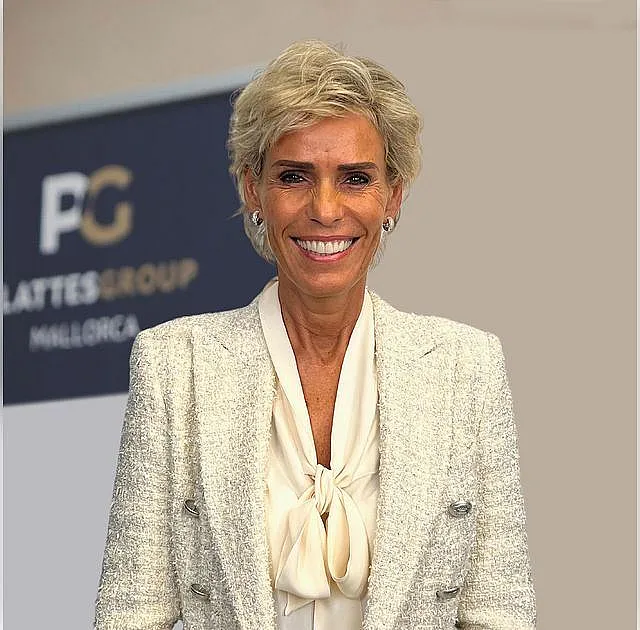 Yvonne Plattes, Gründerin der PlattesGroup und Leiterin der Rechtsabteilung, trägt einen weißes Blazer und eine weiße Bluse mit Schleife. Sie hat kurze blonde Haare und lächelt in die Kamera. 